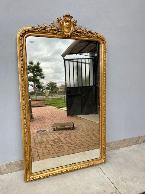 Louis Philippe mirror in carved and leaf-gilded wood.