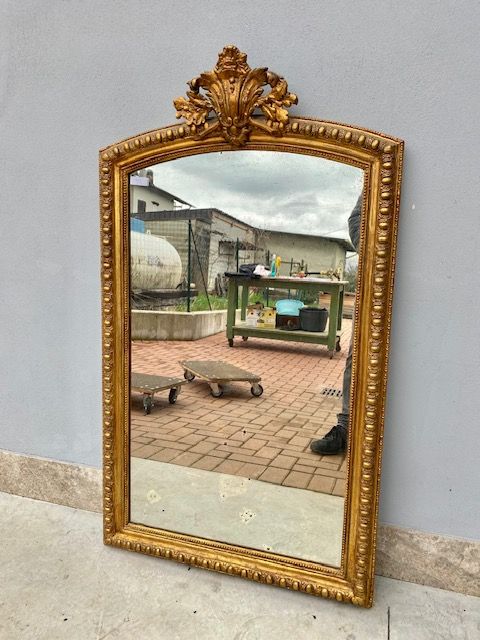 Louis Philippe mirror in carved and leaf-gilded wood.