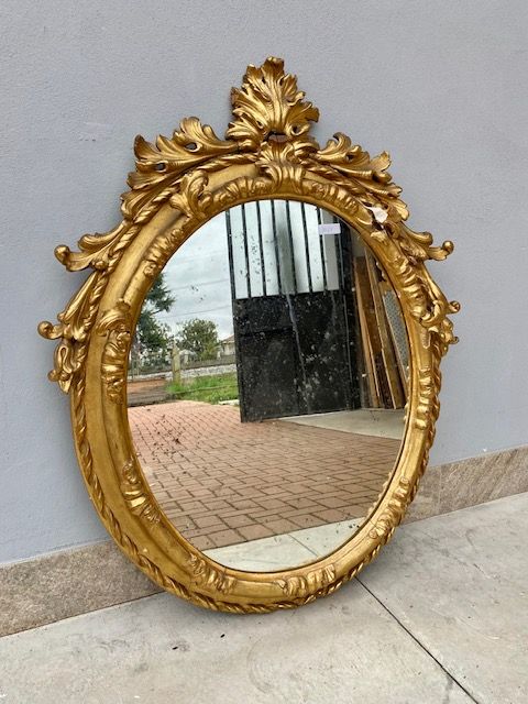 Charles X Oval Mirror in Carved and Leaf-Gilded Wood.
