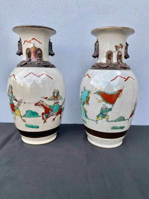 Pair of Chinese Porcelain Vases, depicting warriors and dragons in relief.